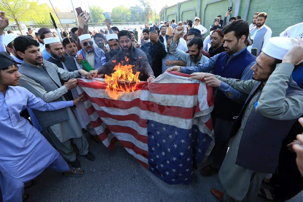 Сторонники Jamaat-e-Islami сжигают флаг США во время акции протеста у здания американского консульства в Пешаваре, Пакистан, 21 марта 2025 года. Фото: Arshad Arbab / EPA