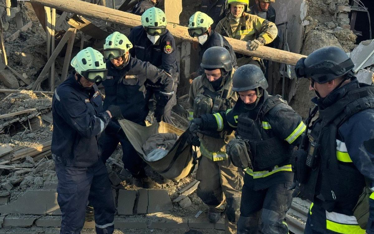 Emergency services carry the body of a woman who was killed in a Russian attack on a residential building in Zaporizhzhia, Ukraine, 22 September 2025. Photo: State Emergency Service of Ukraine