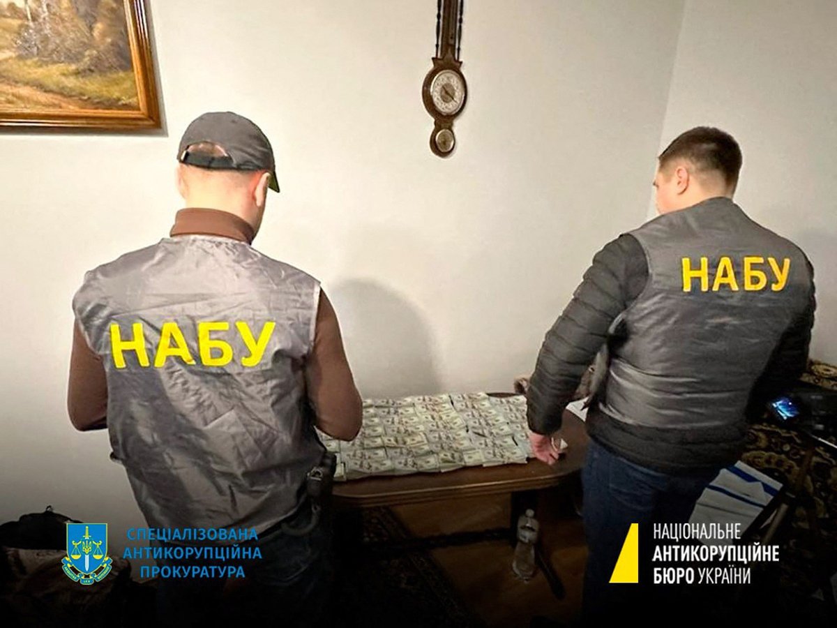 Сотрудники НАБУ рядом с изъятыми деньгами, 23 января 2023 года. Фото: AFP / Scanpix / LETA