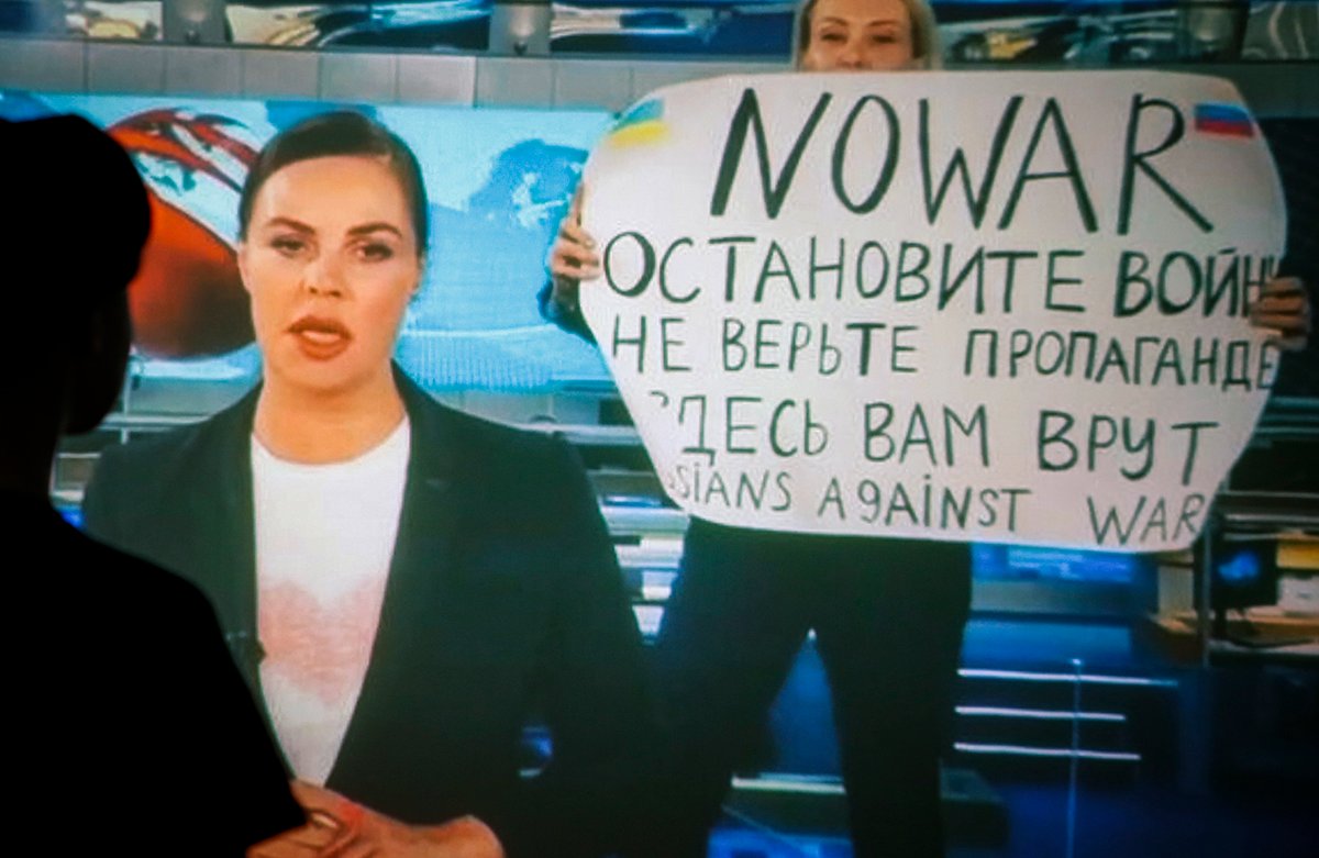 Женщина смотрит запись вечернего выпуска новостей Первого канала, в котором Марина Овсянникова появилась с написанным от руки антивоенным плакатом, Москва, Россия, 15 марта 2022 года. Фото: EPA / DSK